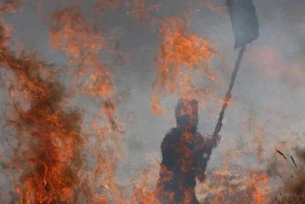 Seorang petani berusaha memadamkan kebakaran yang dicetuskan pelampau Yahudi di sebuah ladang pertanian di perkampungan Asira al-Qibliya, selatan Nablus. - AFP