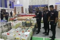 Hussein (kiri) menunjukkan peralatan dan bahan prekursor yang dipercayai digunakan dalam kegiatan pemprosesan dadah