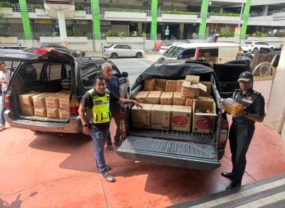 Hanif Yusabra (kanan) memeriksa minyak masak yang dirampas di Pasir Mas.
FOTO SINAR HARIAN - ADILA SHARINNI WAHID