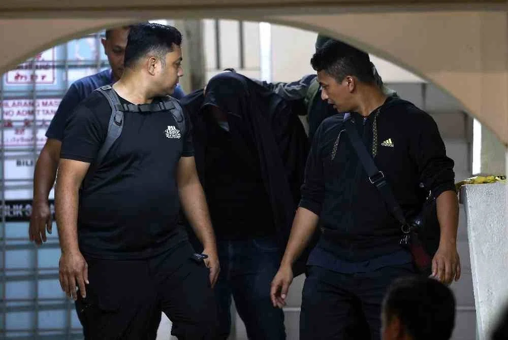 Seorang lelaki yang dipercayai suami kepada pegawai wanita Jabatan Kastam Diraja Malaysia (JKDM) yang ditemukan maut, dibawa oleh anggota polis berhampiran kediaman di Kuarters Lapangan Terbang Antarabangsa Kuala Lumpur (KLIA) bagi membantu siasatan. Foto Bernama