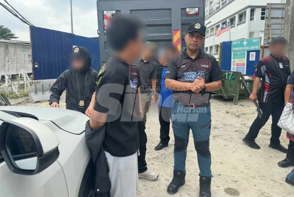 Lokman Effendi (kanan) menyoal siasat seorang lelaki disyaki transpotter PATI.
