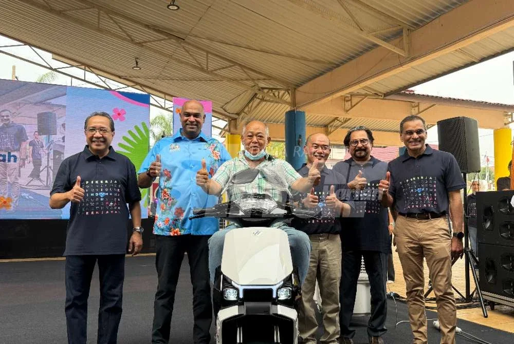 Ramanan (dua dari kiri) bergambar bersama pemenang cabutan bertuah yang membawa pulang motosikal elektrik.