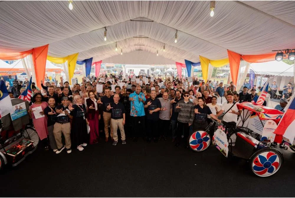 Ramanan (tengah) bergambar bersama orang ramai yang hadir memeriahkan program i LINDUNG u Gegar di Dataran keris, Melaka pada Sabtu.