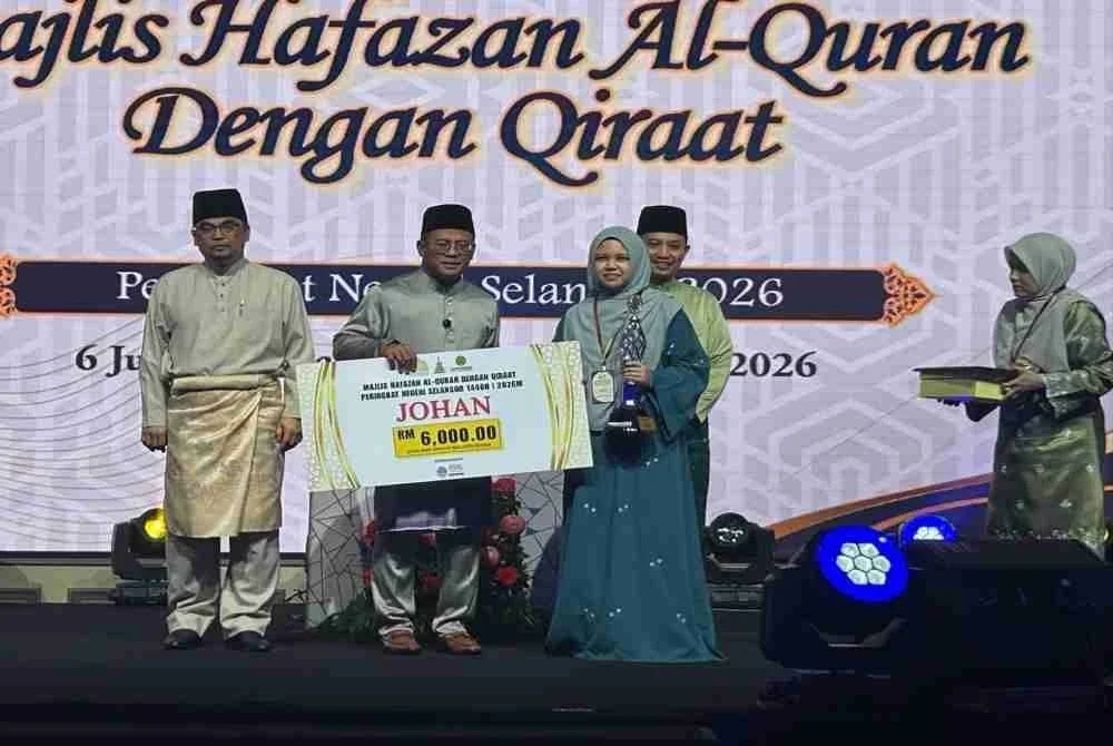 Amirudin (tengah) menyampaikan hadiah kemenangan kepada johan kategori wanita Hafazan Al-Quran dengan Qiraat Peringkat Negeri Selangor di Dewan Syarahan dan Muzakarah Islam di sini pada Sabtu.