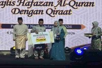 Amirudin (tengah) menyampaikan hadiah kemenangan kepada johan kategori wanita Hafazan Al-Quran dengan Qiraat Peringkat Negeri Selangor di Dewan Syarahan dan Muzakarah Islam di sini pada Sabtu.