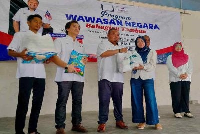 Muhammad Fadhli (tengah) menyempurnakan Majlis Sumbangan Kotak Makanan kepada Rakyat Wawasan Tambun di Dewan Anggerik, Kampung Ulu Chemor di sini pada Sabtu.