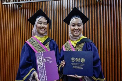 Puteri Sofea Nabeeha (kanan) bersama Puteri Sofea Nabeela (kiri) bergambar pada Majlis Istiadat Konvokesyen UiTM ke-105. - Foto Bernama. 