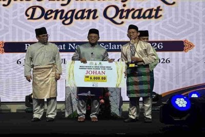 Amirudin (tengah) menyampaikan penghargaan kepada johan Hafazan Al-Quran dengan Qiraat Peringkat Negeri Selangor di Dewan Syarahan dan Muzakarah Islam di sini pada Sabtu.