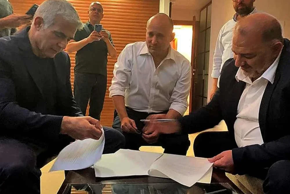 Dari kiri: Yair Lapid, Naftali Bennett dan Mansour ketika menandatangani perjanjian untuk menyertai kerajaan gabungan pada 2021.