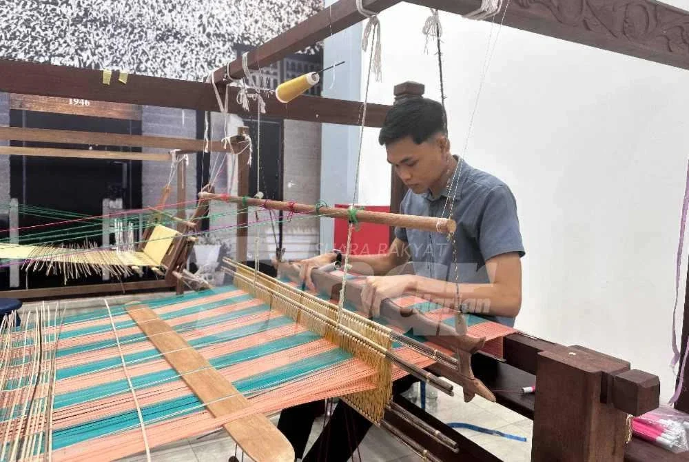  Mohamad Sharil tekun menyiapkan songket ditempah pelanggan. 