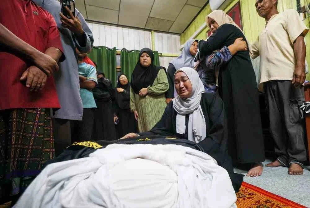 Ahli keluarga tidak dapat menahan sebak ketika jenazah pegawai Agensi Kawalan dan Perlindungan Sempadan Malaysia (AKPS) Norhazwani Ibrahim, 35, tiba di rumah keluarganya 1.10 pagi untuk disolatkan di Kampung Banjir, Telaga Lanas, Pengkalan Kubor awal pagi tadi. Foto Bernama