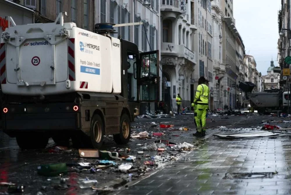 Kakitangan majlis perbandaran membersihkan sisa sampah akibat 'amukan' demonstran di Marseille pada Ahad. Foto AFP