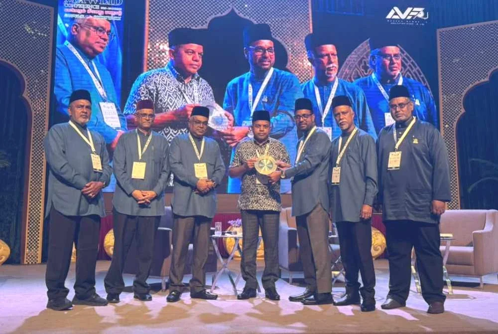 Ayob Khan (tengah) menerima cenderahati pada Konvensyen Perdana Ceramah Maulidur Rasul 2026 Siri Ke-6 di Dewan Matrade pada Ahad.