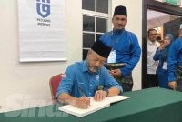 Mukhriz menandatangani buku pelawat ketika hadir merasmikan Persidangan Tahunan Pejuang Negeri Perak 2026 di Dewan Banquet, Hotel Seri Malaysia pada Ahad.