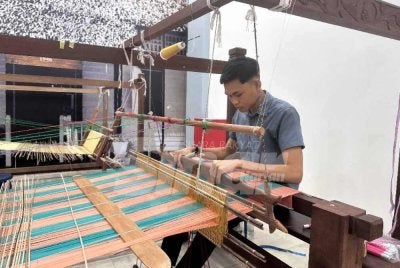 Mohamad Sharil tekun menyiapkan songket ditempah pelanggan. 