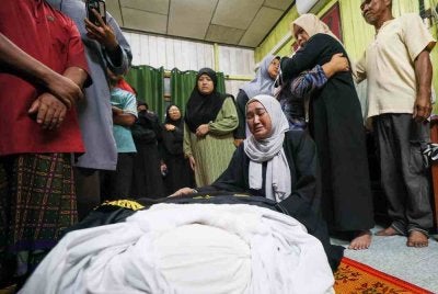 Ahli keluarga tidak dapat menahan sebak ketika jenazah pegawai Agensi Kawalan dan Perlindungan Sempadan Malaysia (AKPS) Norhazwani Ibrahim, 35, tiba di rumah keluarganya 1.10 pagi untuk disolatkan di Kampung Banjir, Telaga Lanas, Pengkalan Kubor awal pagi tadi. Foto Bernama