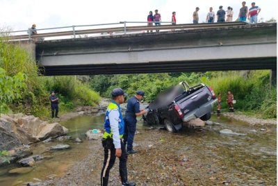 Keadaan pacuan empat roda yang dipandu mangsa selepas terjunam ke dalam sungai di Ranau pada Ahad. - FOTO: Polis 