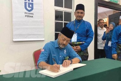 Mukhriz menandatangani buku pelawat ketika hadir merasmikan Persidangan Tahunan Pejuang Negeri Perak 2026 di Dewan Banquet, Hotel Seri Malaysia pada Ahad.