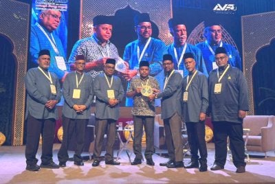 Ayob Khan (tengah) menerima cenderahati pada Konvensyen Perdana Ceramah Maulidur Rasul 2026 Siri Ke-6 di Dewan Matrade pada Ahad.