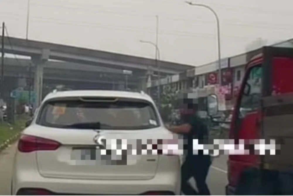 Tangkap layar video yang tular memaparkan seorang lelaki menumbuk cermin sisi kereta kerana membuat pusingan U di Taman Sentosa, Johor Bahru.