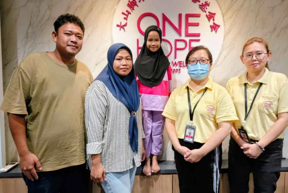 Nur Anis (tengah) bersama ibu bapanya serta kakitangan One Hope Charity & Welfare.