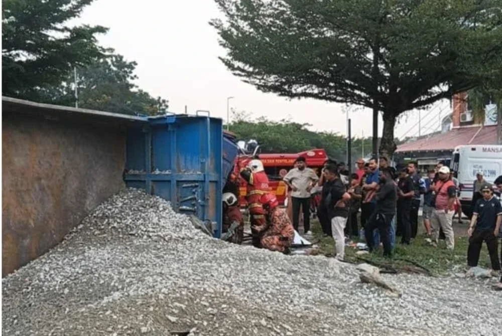 Anggota bomba bertindak segera menyelamatkan pemandu lori dalam kemalangan di Jalan Pulau Lumut di Shah Alam pada Isnin. - FOTO: JBPM Selangor