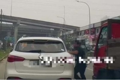 Tangkap layar video yang tular memaparkan seorang lelaki menumbuk cermin sisi kereta kerana membuat pusingan U di Taman Sentosa, Johor Bahru.