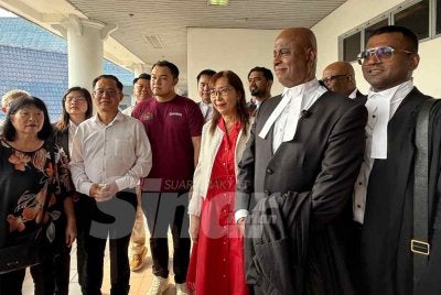 Sankara (depan, kanan) dan Teresa selepas mendengar keputusan saman fitnah di Mahkamah Tinggi Melaka pada Isnin.