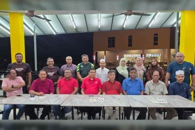 Mohamad Ali (empat dari kiri, duduk) mempengerusikan mesyuarat bersama Bersatu Jasin pada Ahad.