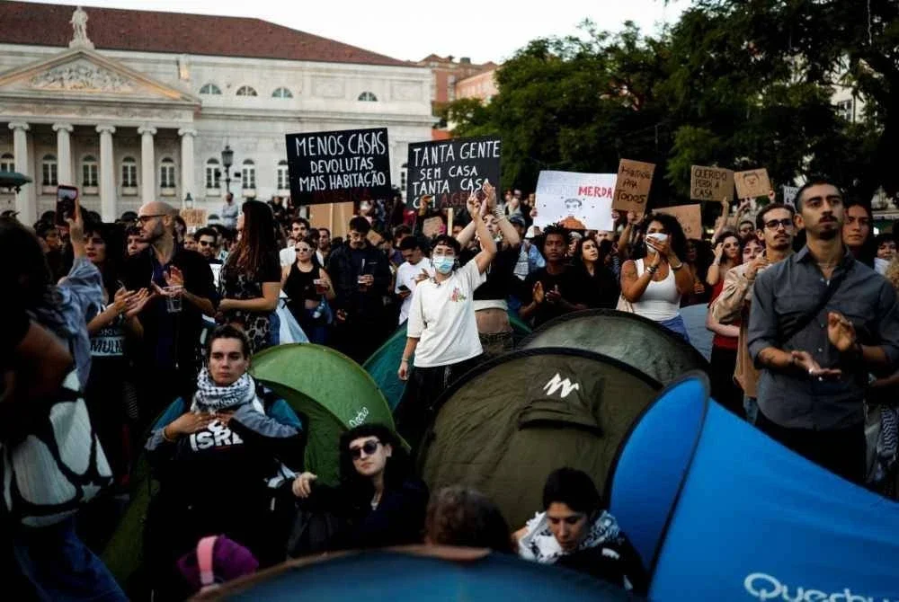 Peserta protes turut mendirikan khemah ketika berhimpun di Lisbon. - FOTO: AFP