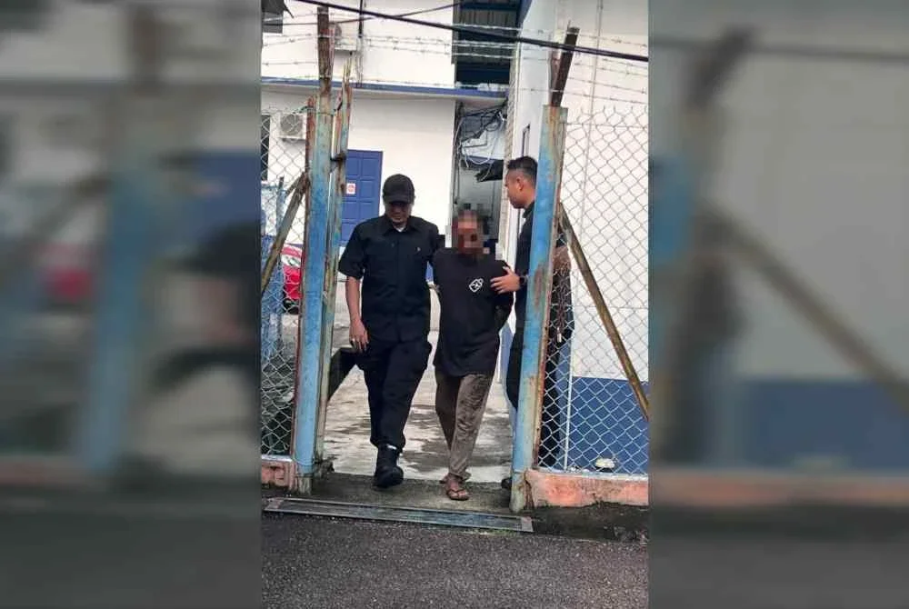Suspek (tengah) dibawa keluar dari lokap menuju ke bilik mahkamah bagi mendapatkan perintah reman. 