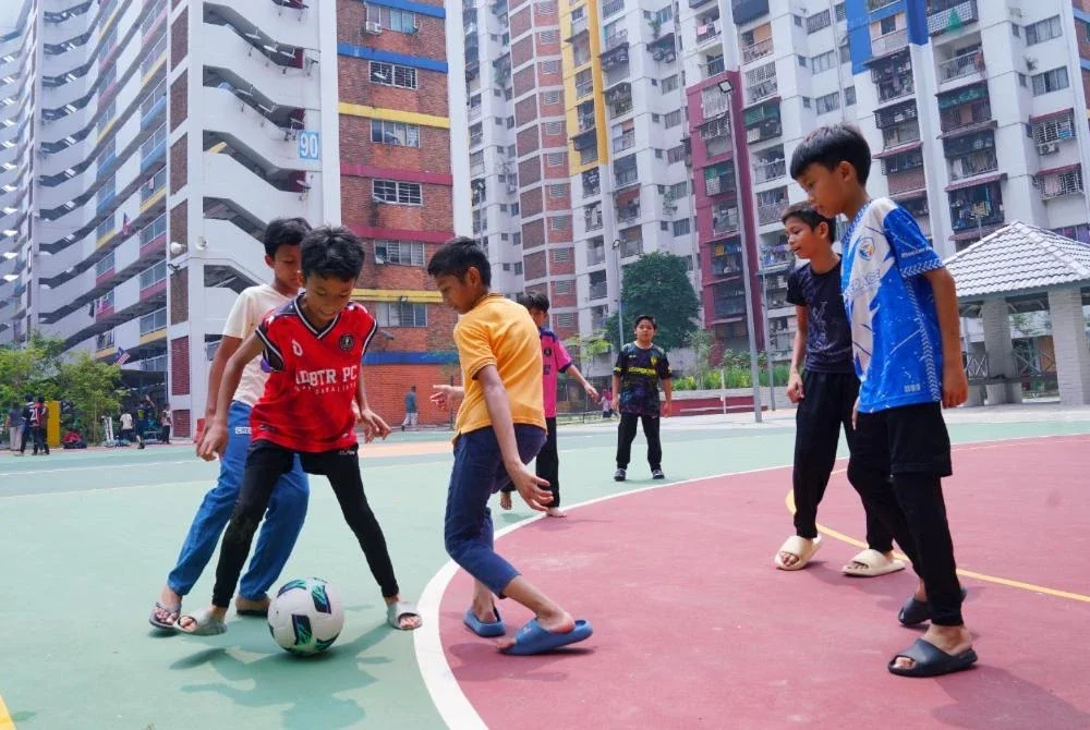 Kanak-kanak bermain bola di Dataran Seri Kota.