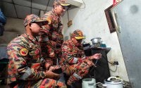Nor Arifin(kanan) memeriksa penyambungan elektrik yang dilakukan di sebuah asrama pekerja warga asing 