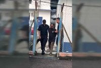 Suspek (tengah) dibawa keluar dari lokap menuju ke bilik mahkamah bagi mendapatkan perintah reman. 