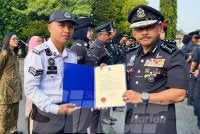 Mohd Yusoff (kanan) menyampaikan surat penghargaan kepada anggota yang cemerlang dalam tugas. 