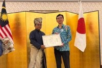 Isrami kiri ketika menerima plak penghargaan daripada Shikata Noriyuki.