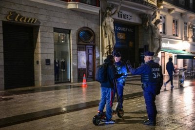 French police officers check a person during a partial curfew in Lyon on October 19, 2026, following weekend demonstrations over soaring prices degenerated into some of the worst street violence in recent years. France announced partial curfews in Paris and other cities that would be enforced from October 19 evening to October 20 morning in a number of cities including Paris, Lille and Lyon, to protect businesses. (Photo by OLIVIER CHASSIGNOLE / AFP)
