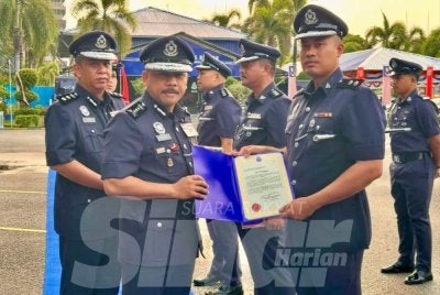 Mohd Yusoff (dua dari kiri) menyampaikan sijil penghargaan kepada pegawai yang cemerlang dalam tugas.