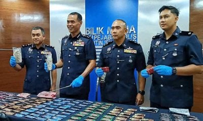 Azry (tiga dari kanan) menunjukkan dadah yang dirampas selepas penahanan pasangan suami isteri yang dipercayai bertindak sebagai penghantar dadah. 