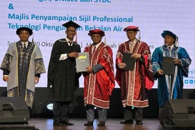Amirudin (tiga dari kanan) menyampaikan Sijil Profesional Teknologi Pengurusan Bekalan Air kepada salah seorang penerima pada Majlis Pelancaran Program Kerjasama Air Selangor, Unisel dan STDC di Shah Alam pada Selasa.