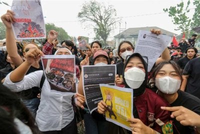 Penunjuk perasaan daripada Perikatan Rakyat Kalimantan Tengah yang Berjuang memegang poster dan cetakan hantaran media sosial bagi mendesak kerajaan mengambil tindakan terhadap kebakaran hutan dan tanah di luar pejabat Gabenor Kalimantan Tengah di Palangkaraya pada Isnin. - Foto AFP
