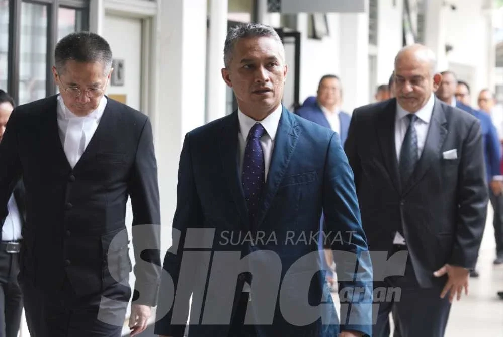 Mohd Shuhaily (tengah) tiba di Mahkamah Majistret Sepang hari ini bagi menghadapi pertuduhan mengasari dua anggota polis. Foto: Rosli Talib
