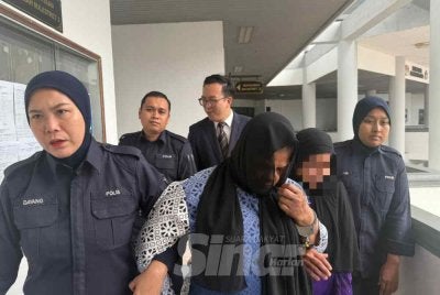 Shofikah (tengah) dihadapkan ke mahkamah atas pertuduhan mencederakan bayi setahun bulan lalu. Foto: Sinar Harian 