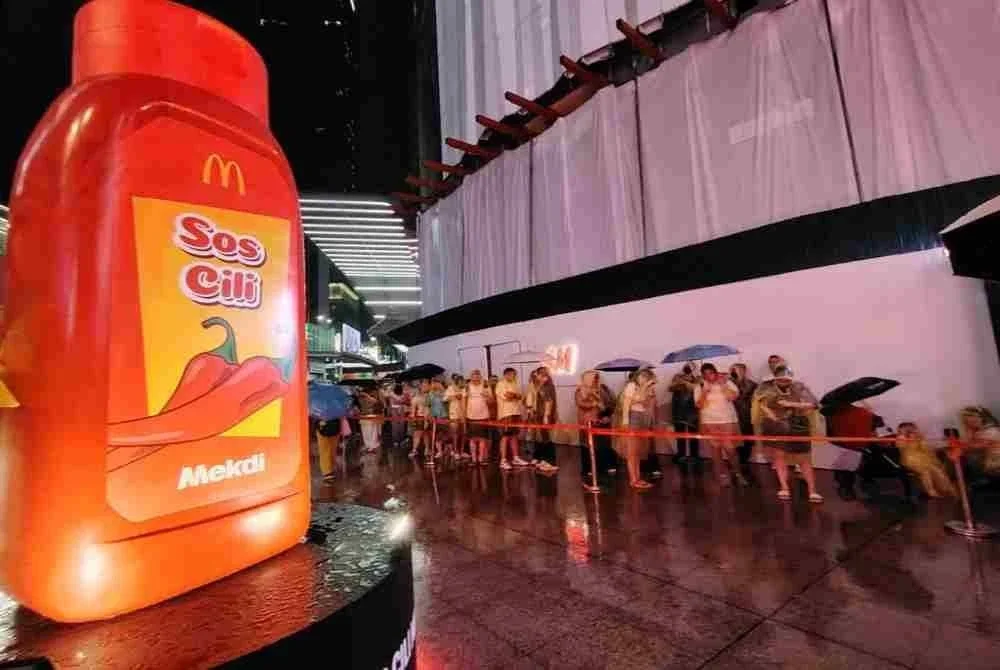 Hujan agak lebat tidak menghalang pelanggan setia McDonald’s untuk beratur panjang bagi menebus sos cili McDonald's di Bukit Bintang 