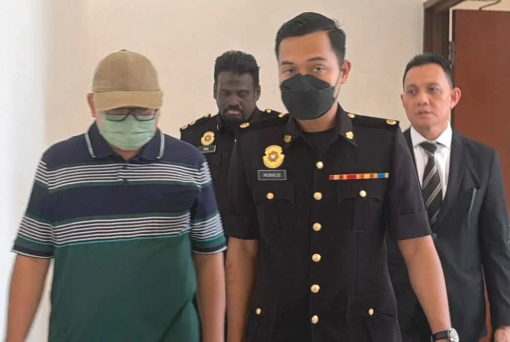 Mohd Rizal (kiri) hadir ke Mahkamah Sesyen Shah Alam pada Selasa.
