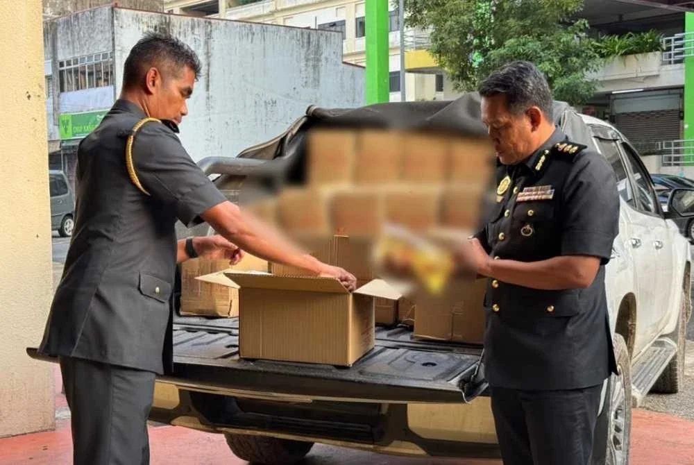 Dua Pegawai KPDN Kelantan memeriksa minyak masak bersubsidi yang cuba diseleweng - FOTO: KPDN