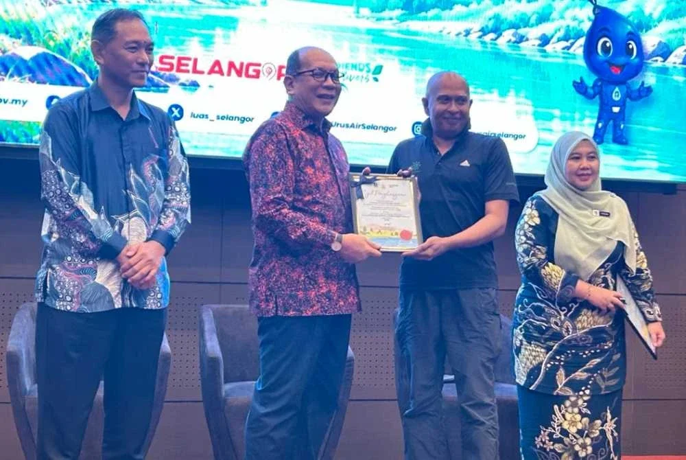 Izham (dua dari kiri) menyampaikan sijil penghargaan kepada salah seorang peserta Bengkel FOR di Shah Alam pada Khamis.
