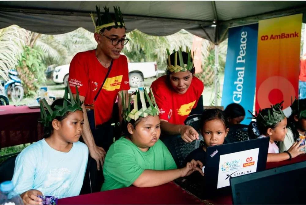 Sukarelawan AmBank mengendalikan kelas literasi digital untuk kanak-kanak Orang Asli di Kampung Sungai Gayung, Pahang, bagi melengkapkan mereka dengan kemahiran digital penting serta peluang pembelajaran.