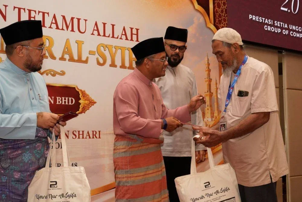 AMIRUDIN menyampaikan sumbangan kelengkapan umrah kepada salah seorang asnaf dalam program Umrah Nur Al-Syifa tajaan PSU Group di Shah Alam baru-baru ini.