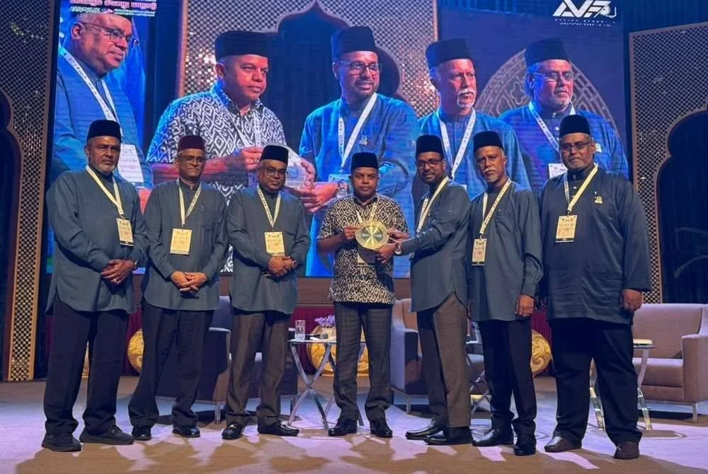 MOHAMED AZMAN SHAH (tiga dari kanan) menyerahkan cenderamata kepada Ayob Khan (tengah) pada persidangan tersebut. 